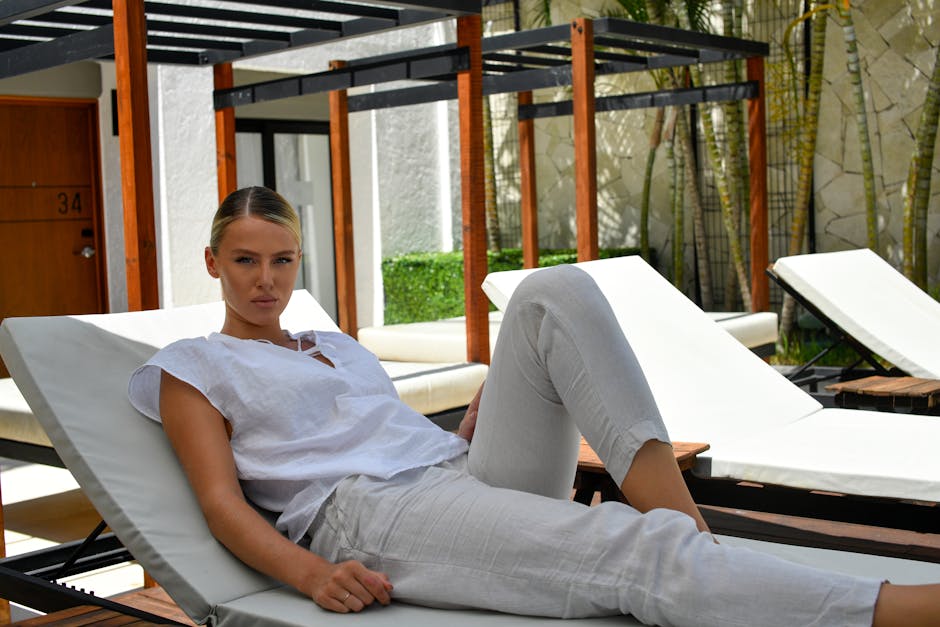 Neatly folded and styled linen clothing pieces in neutral tones arranged for a summer fashion editorial