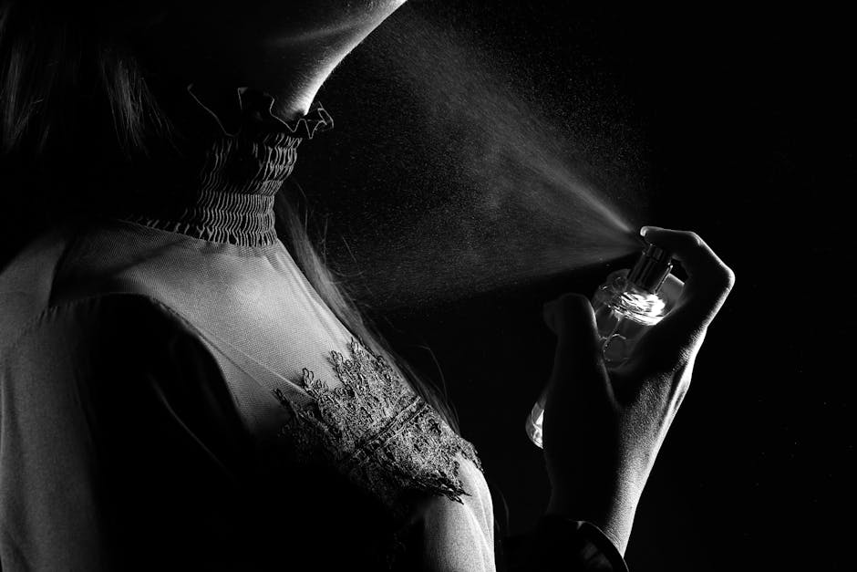 Woman applying perfume outdoors on a warm summer day, enjoying a long-lasting floral fragrance