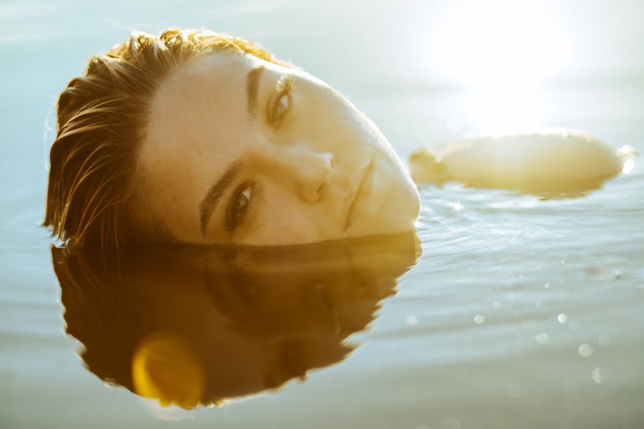 Woman with a natural-looking golden tan applying self-tanning lotion in summer light