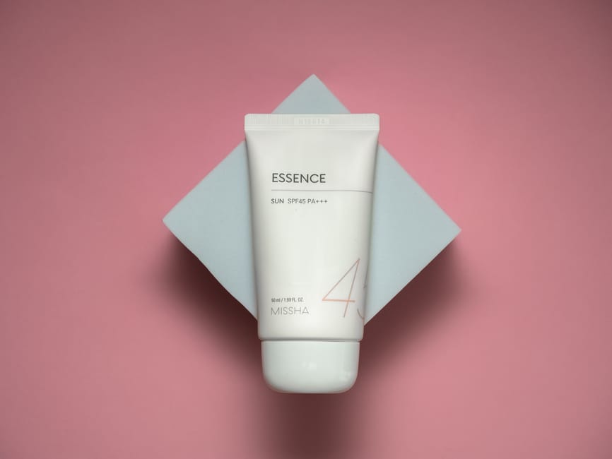 Woman applying SPF moisturiser to her face in natural light