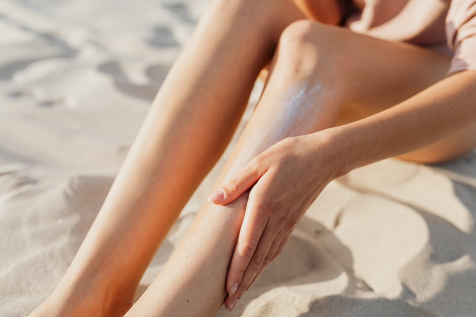 Woman applying after-sun lotion to her shoulders on a sunny beach