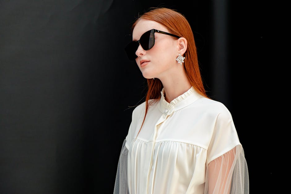 Close-up of a pair of luxury designer sunglasses with gold frame detail on a marble surface