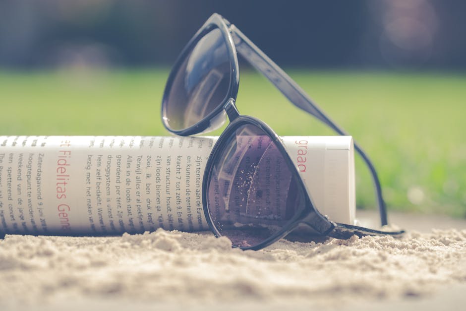 Person wearing stylish designer sunglasses on a sunny beach, ocean in the background