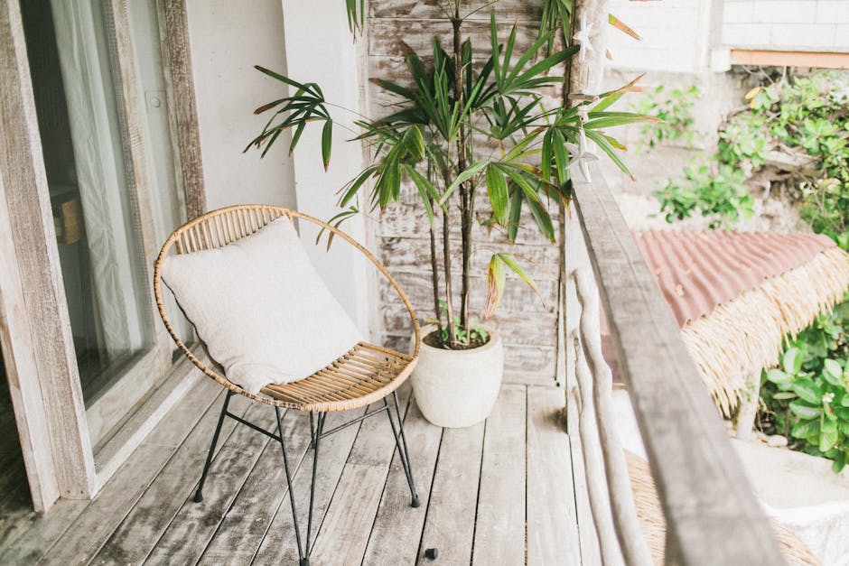 A compact urban balcony styled with colourful outdoor cushions, potted plants and a small bistro table