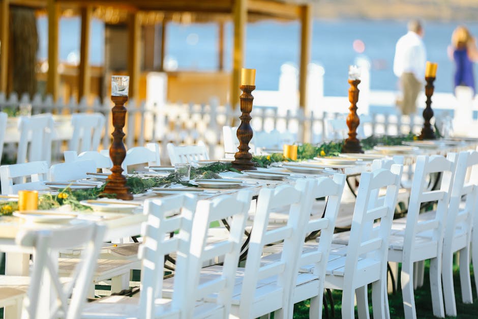 An alfresco dining table set with candles, linen napkins and fresh flowers for a summer garden dinner