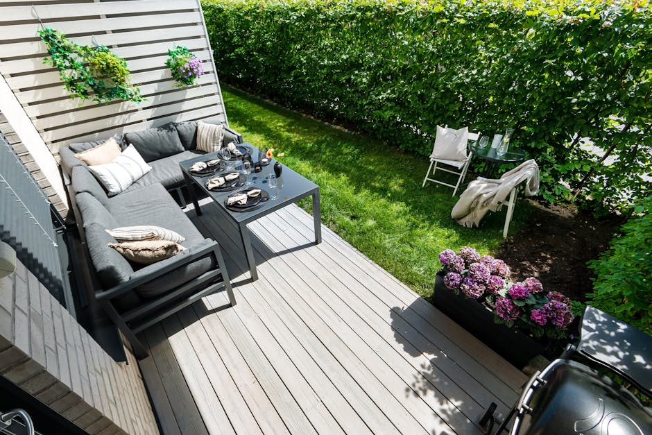 A beautifully styled outdoor garden terrace with cushions, plants and fairy lights for summer alfresco living