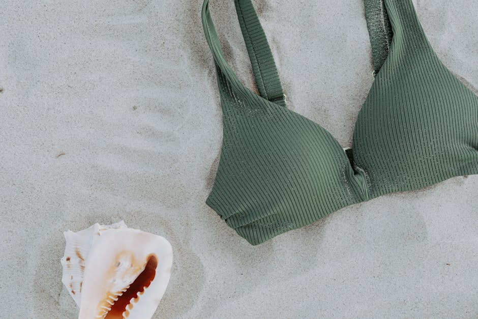 Flat lay of designer swimwear pieces including a one-piece swimsuit and bikini in complementary colours