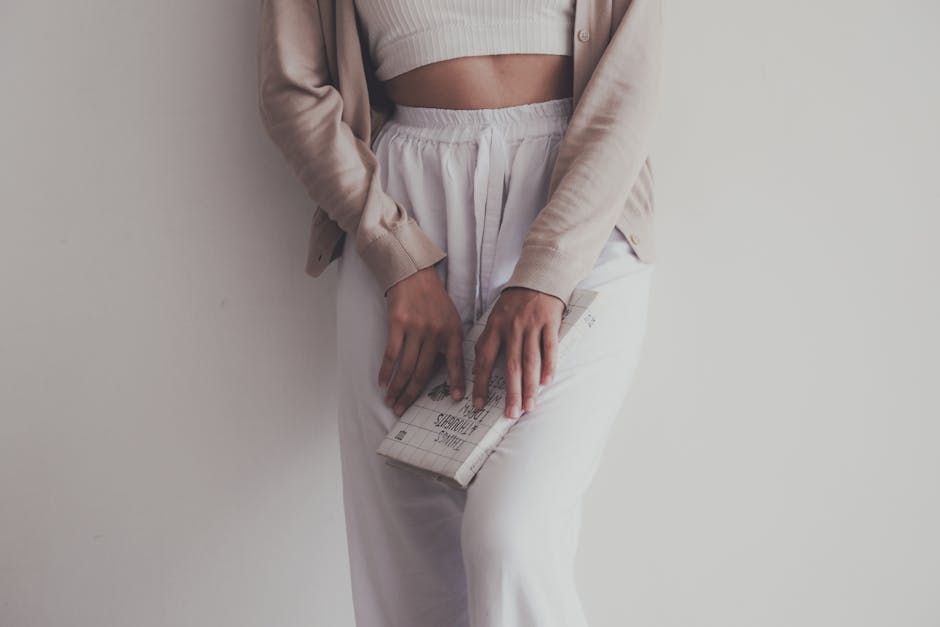 A neatly laid-out flat lay of linen summer clothes including a shirt, trousers, and a light jacket in neutral tones