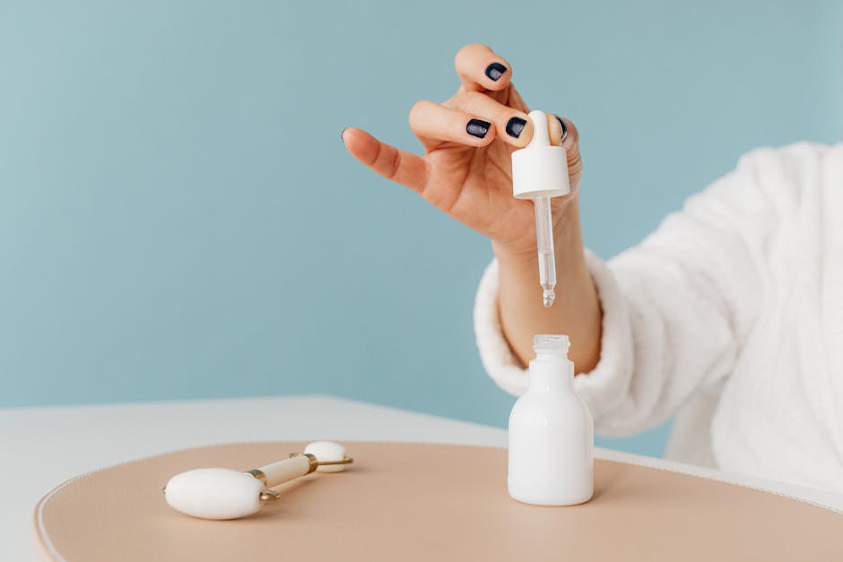 A glass dropper bottle of face serum on a clean white background