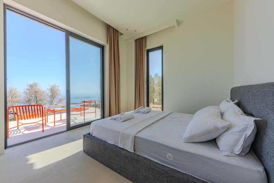 Bright, minimal hotel-style bedroom dressed with white linen bedding and soft natural light for summer