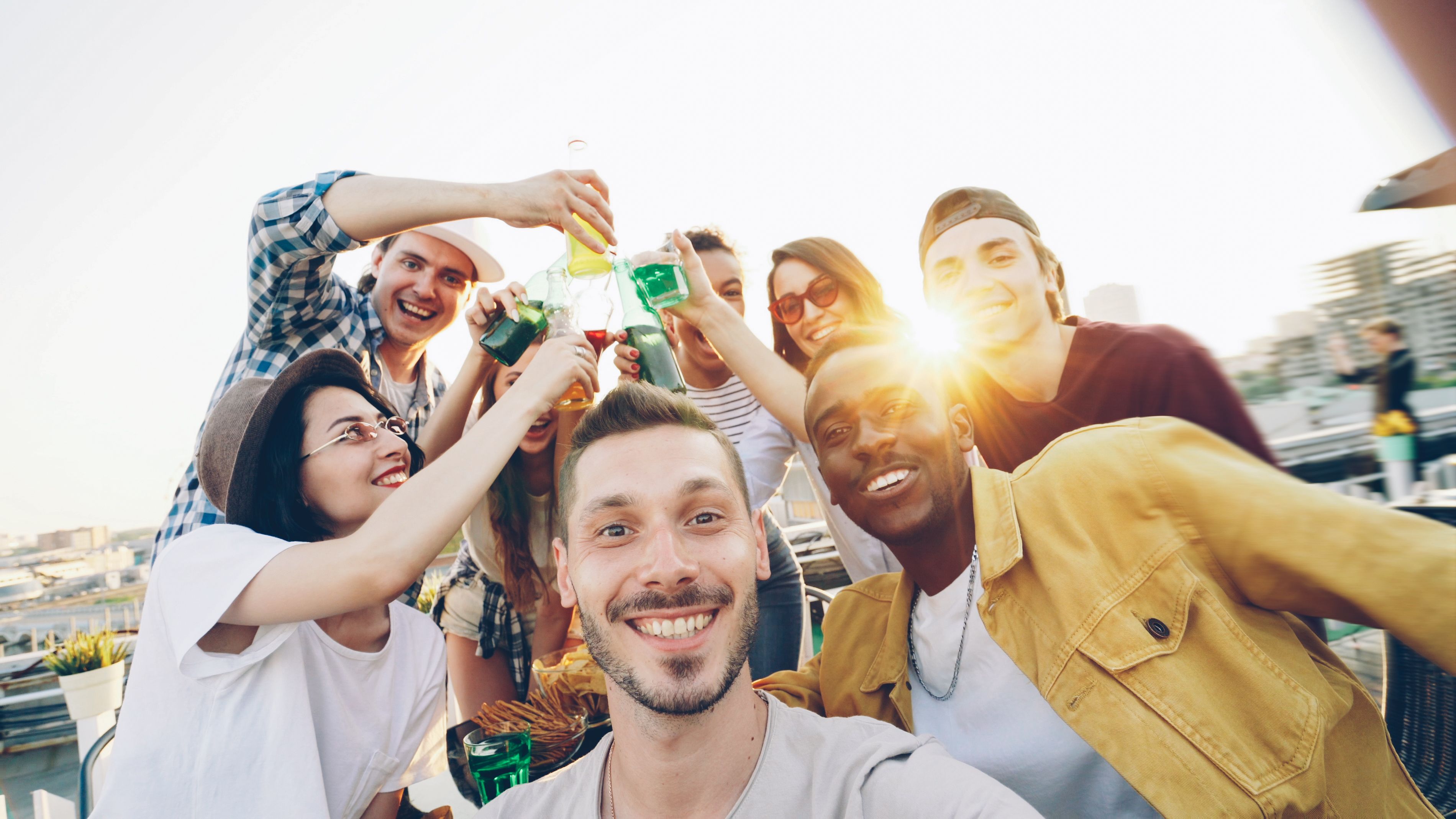 A joyful group of friends toasting and enjoying a sunny outdoor gathering.