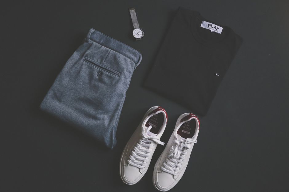 A pair of clean white designer trainers styled with tailored shorts and a colour-block top for a summer casual outfit