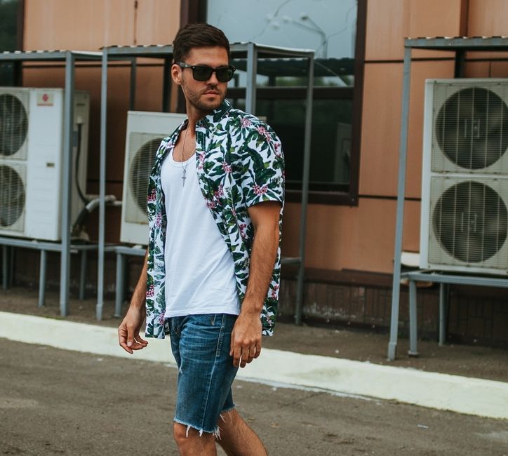A man in a relaxed linen shirt and tailored trousers walking in a city street, styled for a casual summer occasion