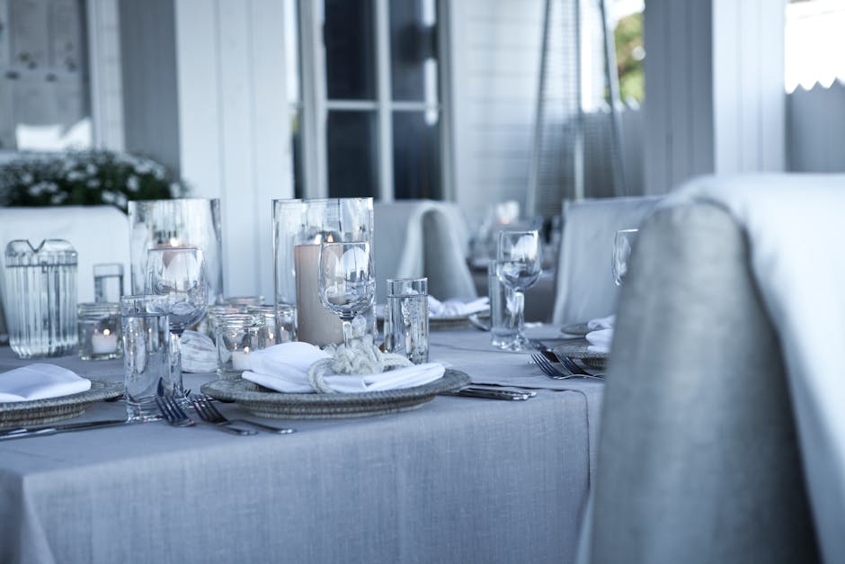 Elegant dining table set with a natural linen tablecloth and ceramic tableware for a summer lunch
