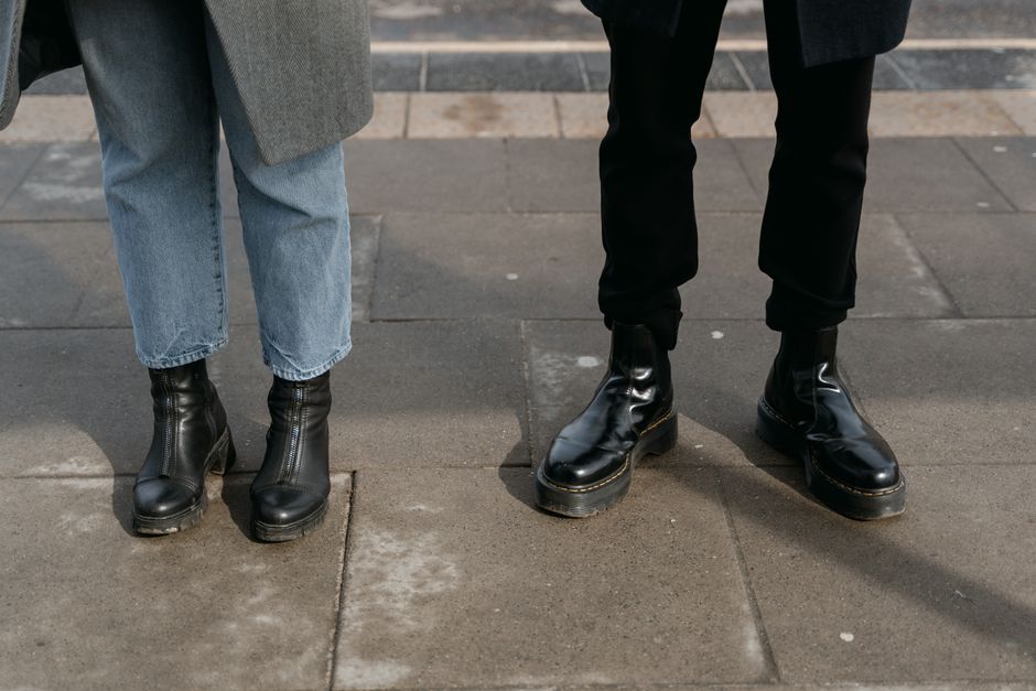A pair of classic Dr. Martens leather boots styled with casual denim on a city street