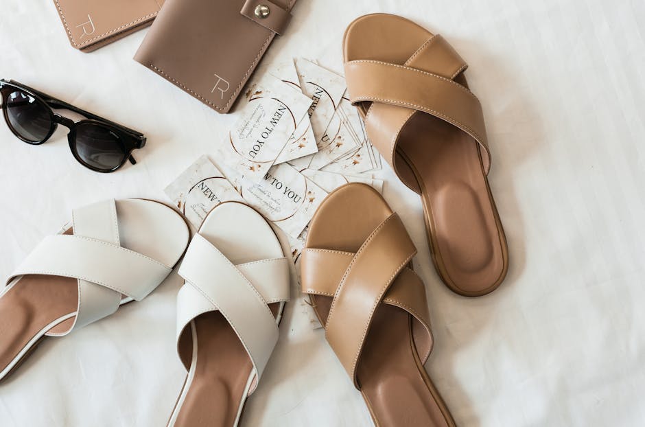 Minimalist tan leather flat sandals on a clean background, a quiet luxury summer essential