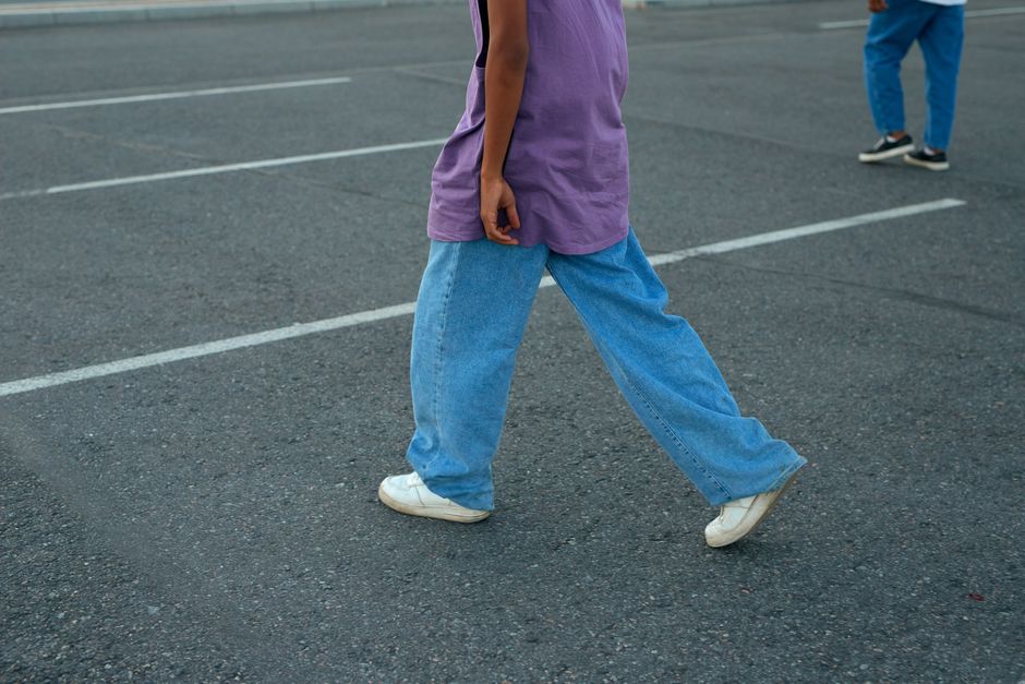 Woman wearing relaxed wide-leg light-wash jeans with a white linen top in summer
