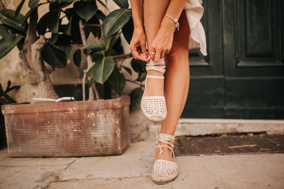 Woman wearing canvas wedge espadrilles with a linen dress on a sunny cobbled street