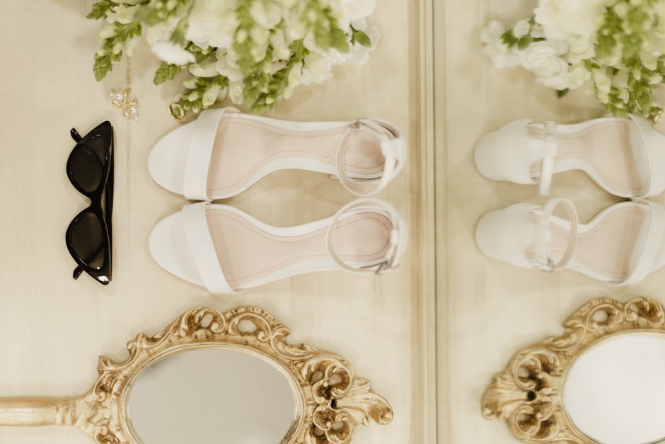 Flat lay of a curated summer shoe wardrobe including sandals, espadrilles and slides on a light background