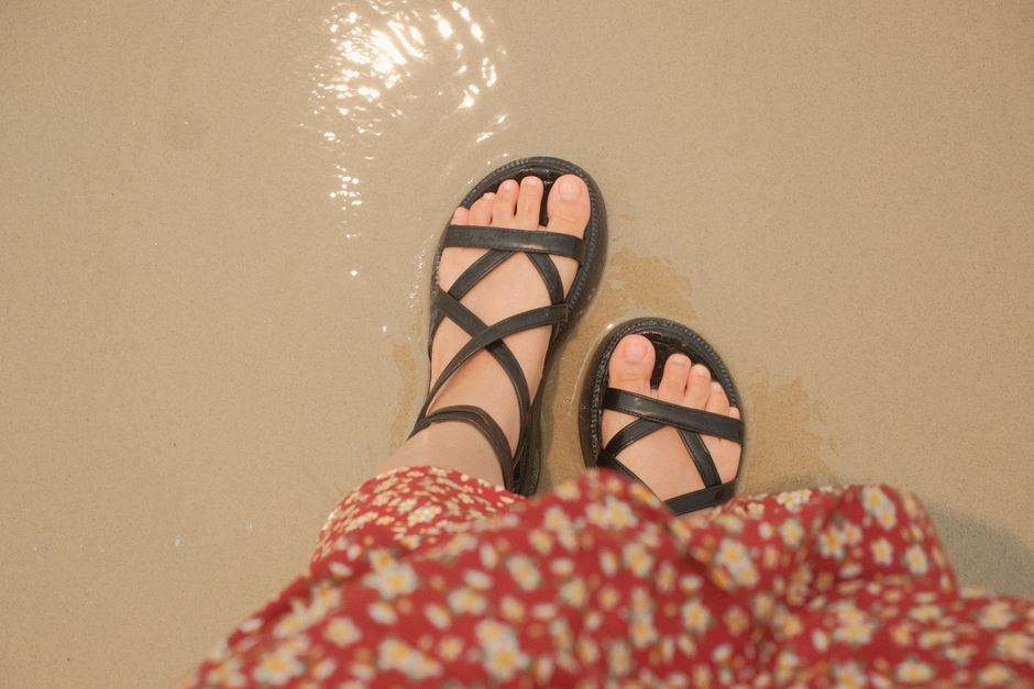 Stylish women's summer sandals and espadrilles arranged on a sunny Mediterranean-style terrace