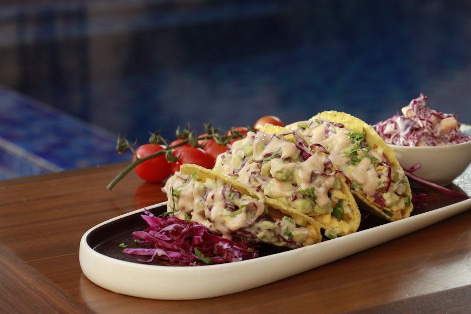 Prawn tacos with mango salsa and fresh coriander served on a wooden board outdoors