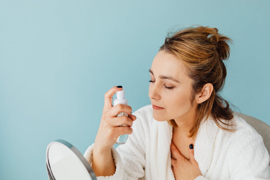 Woman spritzing setting spray over finished makeup look for long-lasting summer beauty