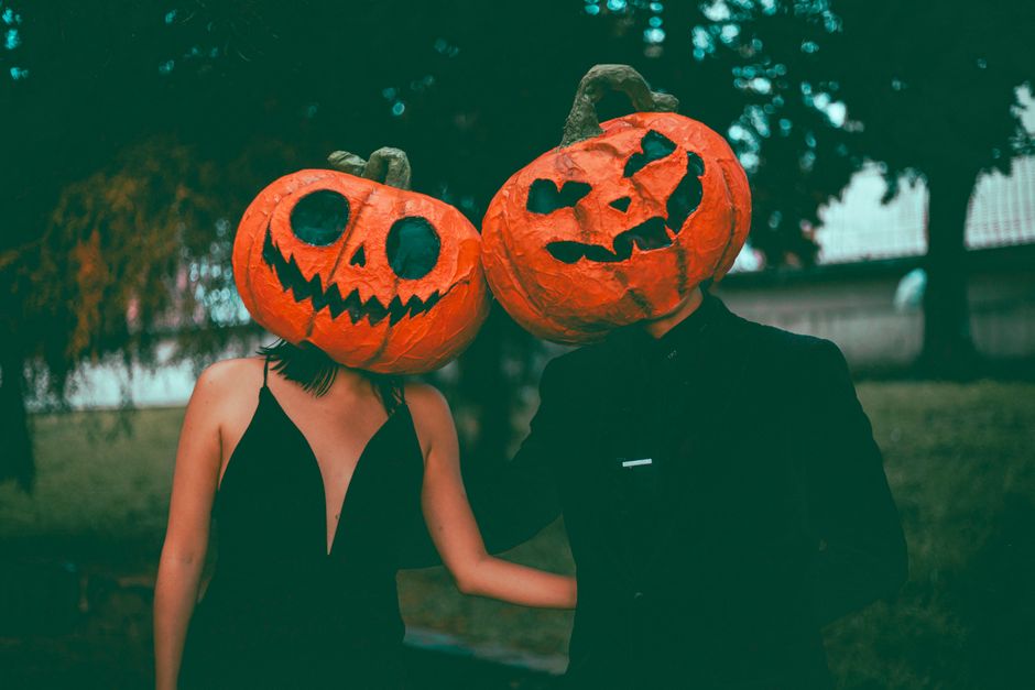 A couple in coordinated Halloween costumes posing together at an evening party