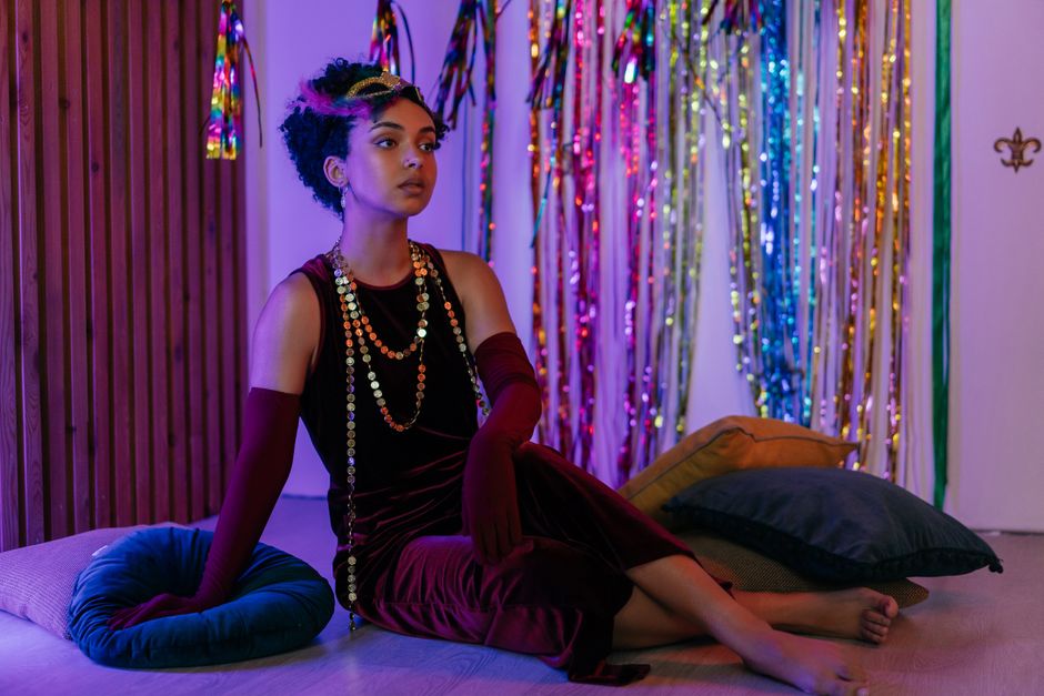 A rich burgundy velvet party dress laid flat on a dark background, ideal for a Halloween party