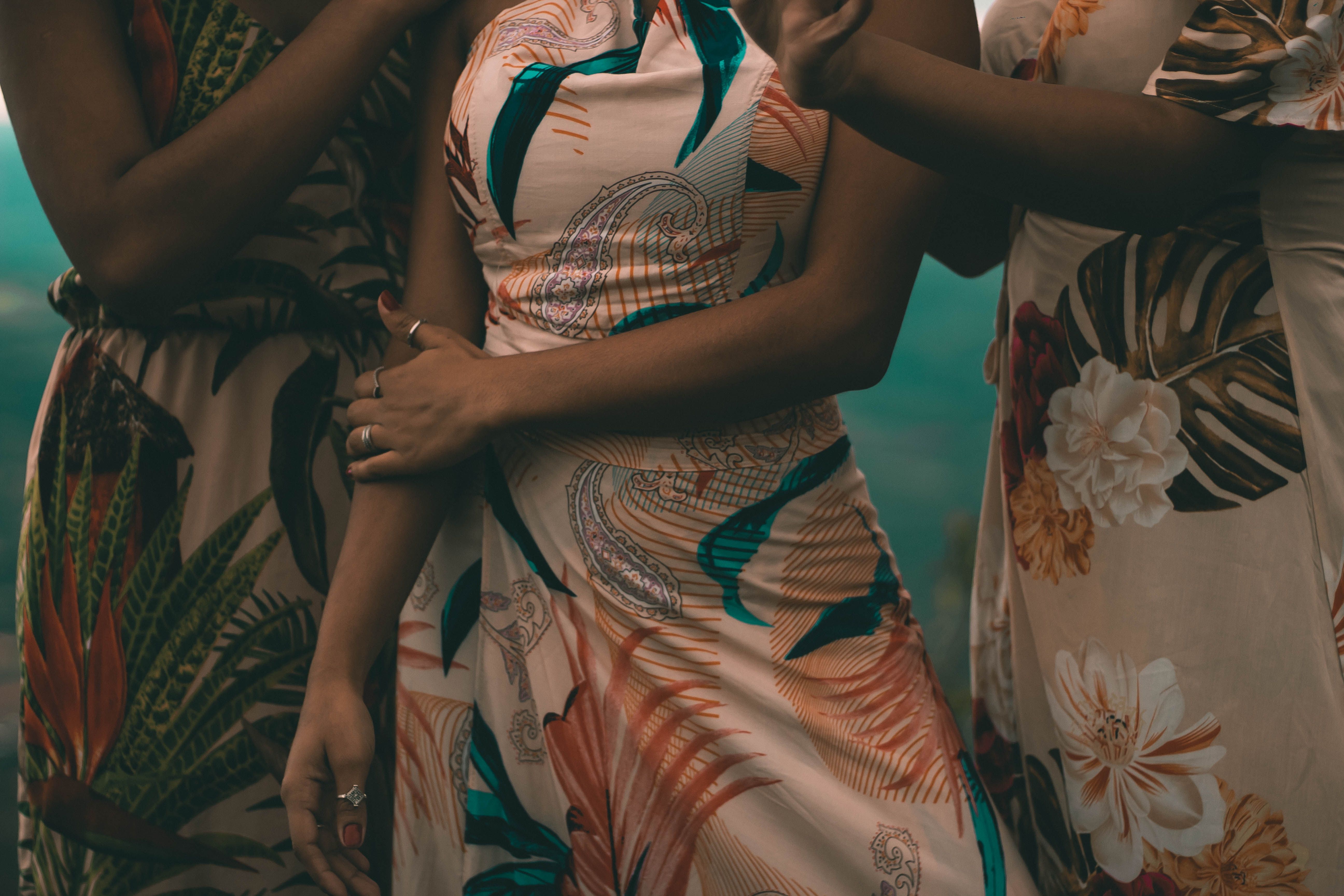 A stylish group of women in floral dresses striking a fashionable pose capturing elegance.