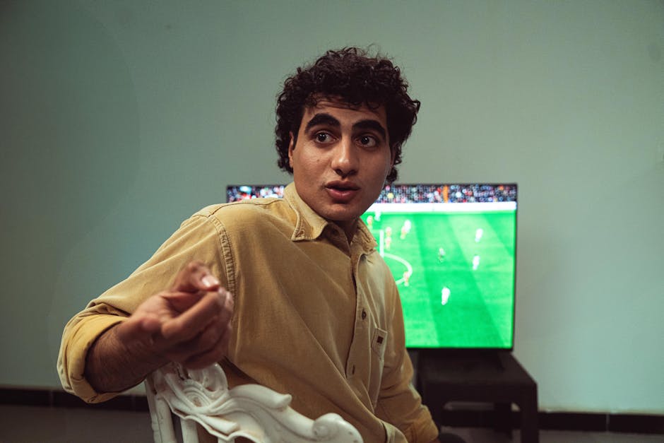 Football fan watching a World Cup match at home with snacks and drinks