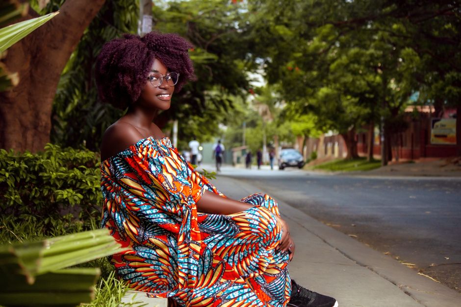 A woman in a bright, lightweight colourful outfit on a sunny summer street