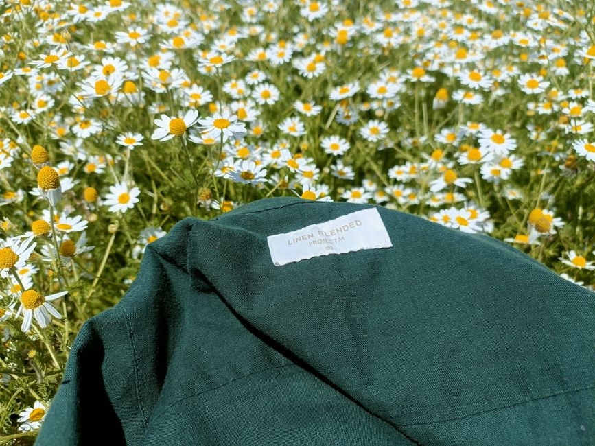 A light linen shirt laid flat, ideal breathable clothing for a summer outdoor festival