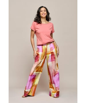 De Corby palazzo broek in een zomers kleurenpalet is dé broek voor dit seizoen! Het unieke geblokte ontwerp van deze damesbroek trekt de aandacht dankzij het effect van de olieverf print. De combinatie van oranje, geel, roze en koraal geeft de broek een echt zomerse uitstraling. Deze losvallende broek sluit mooi aan in de taille, heeft lange rechte pijpen en draagt licht en luchtig. Bovendien straalt de broek een uitgesproken vrouwelijkheid uit door zijn prachtige, soepele stof en wijde pijpen, die elegant om de benen vallen. De sluiting aan de linkerzijde is onzichtbaar weggewerkt in de naad, voor een naadloze afwerking. De kleurrijke palazzo broek heeft steekzakken aan de zijkanten en een zachte elastische tailleband aan de achterkant, wat zorgt voor een comfortabele pasvorm. Deze geprinte palazzo broek mag deze zomer niet ontbreken in je kledingkast.