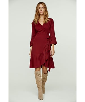 Deze wijndress is vervaardigd uit geweven viscose. Het heeft een V-hals en 3/4 klokmouwen. Deze wikkeljurk heeft een strik aan de linkerkant die door een gat aan de rechterkant wordt geregen en vastgebonden wordt met de strik aan de rechterkant opzij of op de rug. Er is een ruche langs de zoom van ongeveer 15 cm. De maten voor maat 36/S (in cm) zijn: Schouderbreedte-33, Buste-42, Taille-42, Zoom-70, Mouwlengte -Lichaamslengte-95/100. 100% viscose