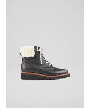 An LKB take on the on-trend winter classic, the hiking-style boot, our Evangeline boots have a feminine feel thanks to their wedge heel. Crafted in Italy from beautifully-soft grainy black leather, they have a round toe, contrast stripe laces, a cream shearling cuff to the ankle and a rugged mini wedge heel. Wear them to dress down your favourite everyday dresses or with jeans and a knit on cold winter days.