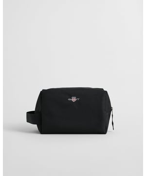 This convenient toiletry bag from GANT is ideal for travel. Made from recycled materials, it has a sturdy handle for easy carrying, a top zip closure with a suede puller, two inner slip pockets, and GANT's iconic shield graphic embroidered at the center.

L 24.5 cm x W 12.5 cm x H 15 cm
Inner slide pockets
GANT graphic embroidered on the front

 Shell - 100% Recycled PolyesterLining - 100% Recycled Polyester 

9970091
 
 