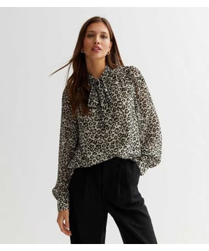 Una blusa de leopardo es un imprescindible en el armario, y aquí tienes tu top versátil. Con un lazo en el cuello y mangas largas, esta Blusa Negra de Estampado Animal con Mangas Largas y Lazo en el Cuello es una elección elegante para el vestuario de oficina o para una ocasión sencilla. Combínala con unos leggings y tacones con tiras para un look estiloso.