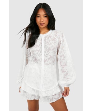 Sheer, textured fabric for a breezy beach look
        Voluminous balloon sleeves add drama
        Button-down front for versatile styling
        Gathered neckline creates a feminine silhouette
        Matching shorts for a coordinated set
    
    Make a statement on your next beach getaway with this eye-catching petite beach shirt. The sheer, textured fabric offers a tantalising glimpse of skin while keeping you cool in the sun. The voluminous balloon sleeves add a touch of drama, perfect for those sunset strolls along the shore. Wear it buttoned up as a chic cover-up over your swimwear, or leave it open for a more relaxed vibe. The gathered neckline creates a flattering, feminine silhouette that's sure to turn heads. Pair it with the matching shorts for a coordinated look that takes you effortlessly from beach to bar. This versatile piece is a must-have for any summer wardrobe, whether you're lounging by the pool or sipping cocktails at a beachside caf.