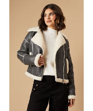 Striking contrast borg detailing for added warmth and style
        Asymmetrical zip front closure for a modern edge
        Oversized collar for a bold, fashion-forward look
        Cropped length perfect for layering
        Versatile design suitable for various casual occasions
    
    This PU borg detail collared zip jacket from Oasis is the epitome of cool-weather chic. The contrasting borg lining not only adds a cosy touch but also creates a striking visual appeal. Its asymmetrical zip closure and oversized collar lend a contemporary edge to your ensemble. The cropped silhouette is ideal for showcasing high-waisted bottoms, as demonstrated by the model pairing it with wide-leg trousers. For a casual day out, style it with your favourite jeans and trainers. Alternatively, dress it up for an evening with friends by layering it over a fitted dress and ankle boots. This jacket is a versatile piece that will quickly become a go-to in your autumn and winter wardrobe, perfect for family gatherings, weekend brunches, or casual outings where you want to make a stylish statement without compromising on comfort.