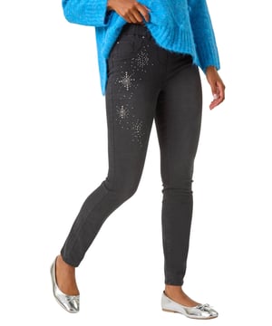 Trim Detail Jegging from Roman. Revamp your Autumn/Winter wardrobe with these embellished trim detail jeggings. These pull-on jeggings in a stretch denim fabric are designed with hotfix and stud details for a touch of sparkle and style. The unique embellishments elevate these jeggings from basic to fabulous. Perfect for a casual yet chic look, pair them with your favourite knitwear and trainers for a trendy and comfortable outfit!