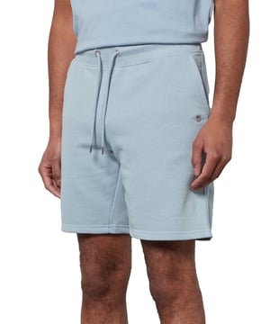 These classic sweat shorts are crafted from a soft cotton blend and tailored for a regular fit. Featuring a ribbed waistband for enhanced comfort, the design includes two front pockets, a single back pocket, and a drawstring waist. Completing the look, the shorts are adorned with a small-scale shield graphic embroidered on the left leg.