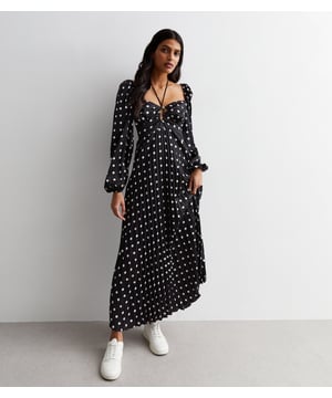 Val op in onze unieke zwarte polkadot geplooide maxi-jurk met uitsnijding. Deze jurk heeft uitsnijdingen aan de voorkant met een gekruiste band, lange mouwen met elastische manchetten en flatterende plooien in de favoriete polka-print aller tijden. Ideaal om te combineren met tijdloze muiltjes en een handtas voor een outfit die klaar is voor een evenement. .