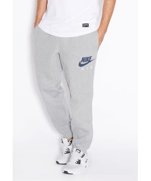 Nike Herren-Fleece-Jogger in Grau.     
Nike Air Signature Branding Druck.     
Reichhaltiges Baumwoll-Mischgewebe mit warmem Fleece-Futter.     
Gummizug in der Taille mit verstellbaren Kordelzügen, gerippte Bündchen.     
Zwei seitliche Einschubtaschen und eine Tasche für die Brieftasche.