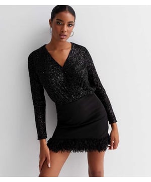 Pailletten Wrap Bodysuit met Lange Mouwen, gemaakt van glinsterende paillettenstof met voering, zorgt ervoor dat je met elke beweging het licht vangt! Dit luxueuze stuk, dat een diepe nep-wikkelontwerp heeft, zal zeker bewonderende blikken trekken op je aankomende feestje.