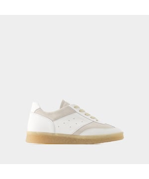De MM6 6 Court Sneakers Maison Margiela belichamen casual elegantie met hun strakke witte leren ontwerp. Ontworpen om stijl en comfort te combineren, zijn deze sneakers voorzien van de verfijnde handtekening van het modehuis en geven ze een eigentijdse touch aan elke outfit. De 6 Court Sneakers zijn perfect voor een verfijnde urban look en weerspiegelen de avant-gardistische esthetiek en uitzonderlijke kwaliteit van het merk. Kleuren: Wit - Blanc. Hoofdmateriaal: generfd kalfsleer. Materiaal zool: rubber. Materiaal voering: leer. Sluiting: veters bovenaan. Tipvorm: rond. Pasvorm: op maat - Maatvoering: Europees.