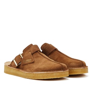This Trek Mule showcases elegance with its polished buckle detail, statement tassel, and signature logo fob. This unique backless design is perched on the renowned natural crepe rubber sole, providing both style and comfort. The caramel coloured suede upper adds a touch of sophistication to the overall look. With a heel height of 25mm, these mules offer a perfect blend of fashion and comfort. Step into a world of timeless style.
