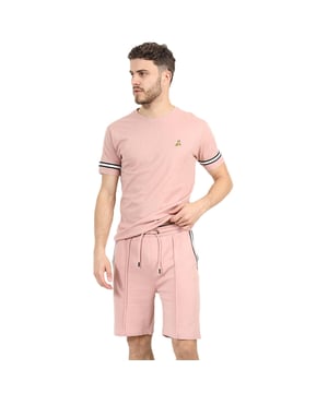 Get ready to embrace endless comfort and style this season with this t-shirt and shorts set from Brave Soul. Crafted from 100% cotton, the crew neck t-shirt features tape detail on the sleeves and embroidery detail on the chest. The matching shorts are made from a soft cotton blend and feature pintuck detail and two waist pockets. This set is the ultimate addition to your casual wardrobe. Model wears UK size M.