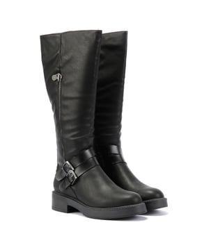 Knee-high boots featuring 2 buckle strap details at the ankle for a stylish touch. Crafted with a soft, faux leather upper for a vegan-friendly and durable design. Complete with a sturdy rubber sole for all-day comfort and traction.