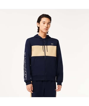 The Joggers tracksuits : Comfortwear Trend Color combination and graphics for a Lacoste dynamic and creative identity. Classic fit  natural ease on body with comfortable sleeves Our classic French terry Cut & sewn colorblock zippered hoodie in mix of two different colors Hood lined in jersey Rib at sleeves and bottom of body Lacoste wording 3D print at right sleeve Embossed Lacoste drawcord 3cm green crocodile at chest.
