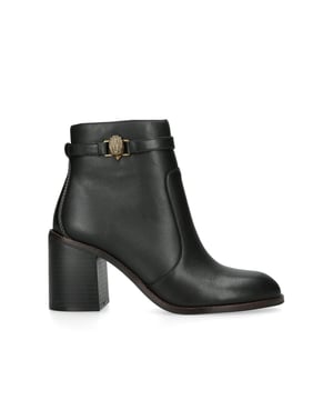 The Kurt Geiger Shoreditch Block Ankle boot is crafted from a black leather. The ankle feature an antiqued brass eagle head with antiqued brass zipper pull on the opposite side. Heel height: 8cm.
